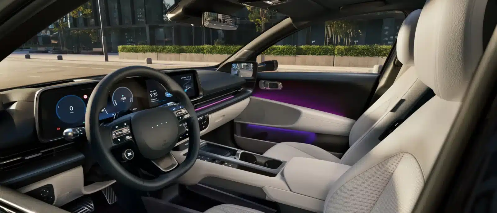 Der Innenraum eines modernen Autos mit digitalem Armaturenbrett, Touchscreen-Display und hellen Sitzen. Entlang der Türen und des Armaturenbretts befindet sich eine violette Beleuchtung, und durch die Fenster ist Grün zu sehen.